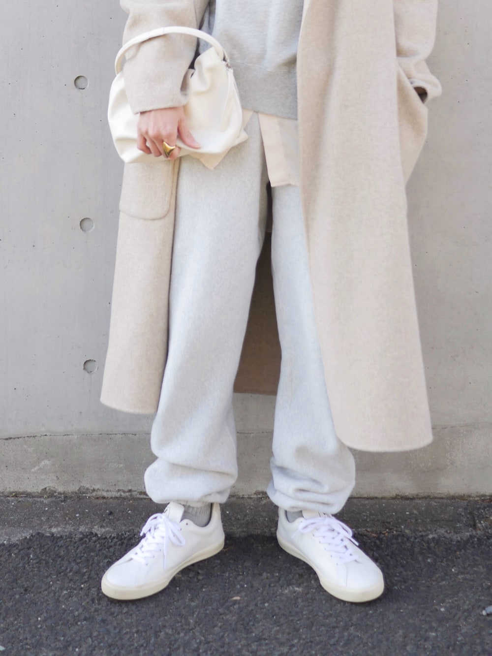 グレー系のスウェットパンツ、ホワイト系のスニーカー、ホワイト系のハンドバッグを着用したレディースの冬コーディネートの3枚目の写真