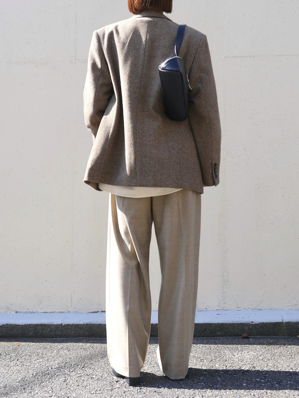 ベージュ系のテーラードジャケット、ベージュ系のその他パンツ、ブラック系のショルダーバッグを着用したレディースの秋コーディネートの3枚目の写真