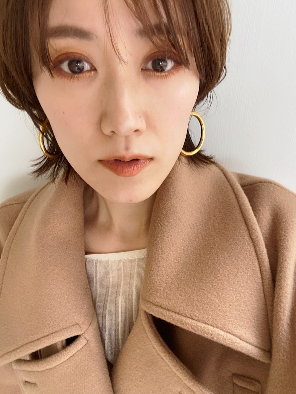 ベージュ系のピーコート、ベージュ系のニット/セーター、ホワイト系のその他パンツを着用したレディースの冬コーディネートの2枚目の写真