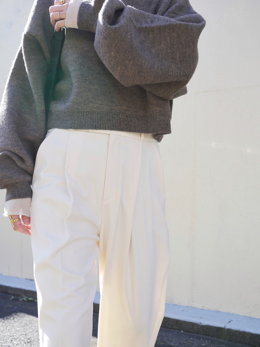 ブラウン系のニット/セーター、ブラック系のブーツ、ホワイト系のTシャツ/カットソーを着用したレディースの冬コーディネートの4枚目の写真