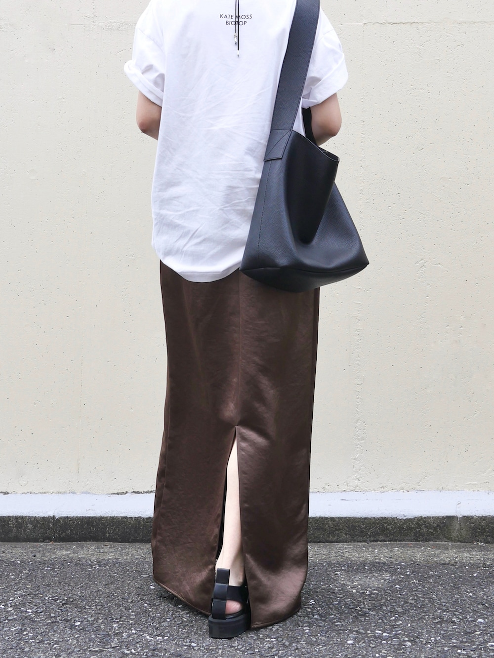 ブラウン系のスカート、ブラック系のサンダル、ブラック系のショルダーバッグを着用したレディースの夏コーディネートの4枚目の写真