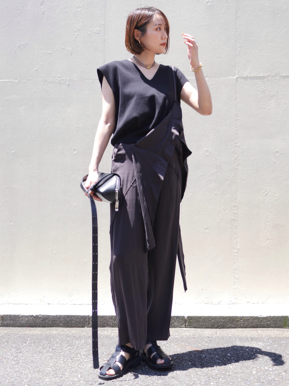 ブラウン系のその他パンツ、ブラック系のニット/セーター、ブラック系のショルダーバッグを着用したレディースの夏コーディネートの4枚目の写真