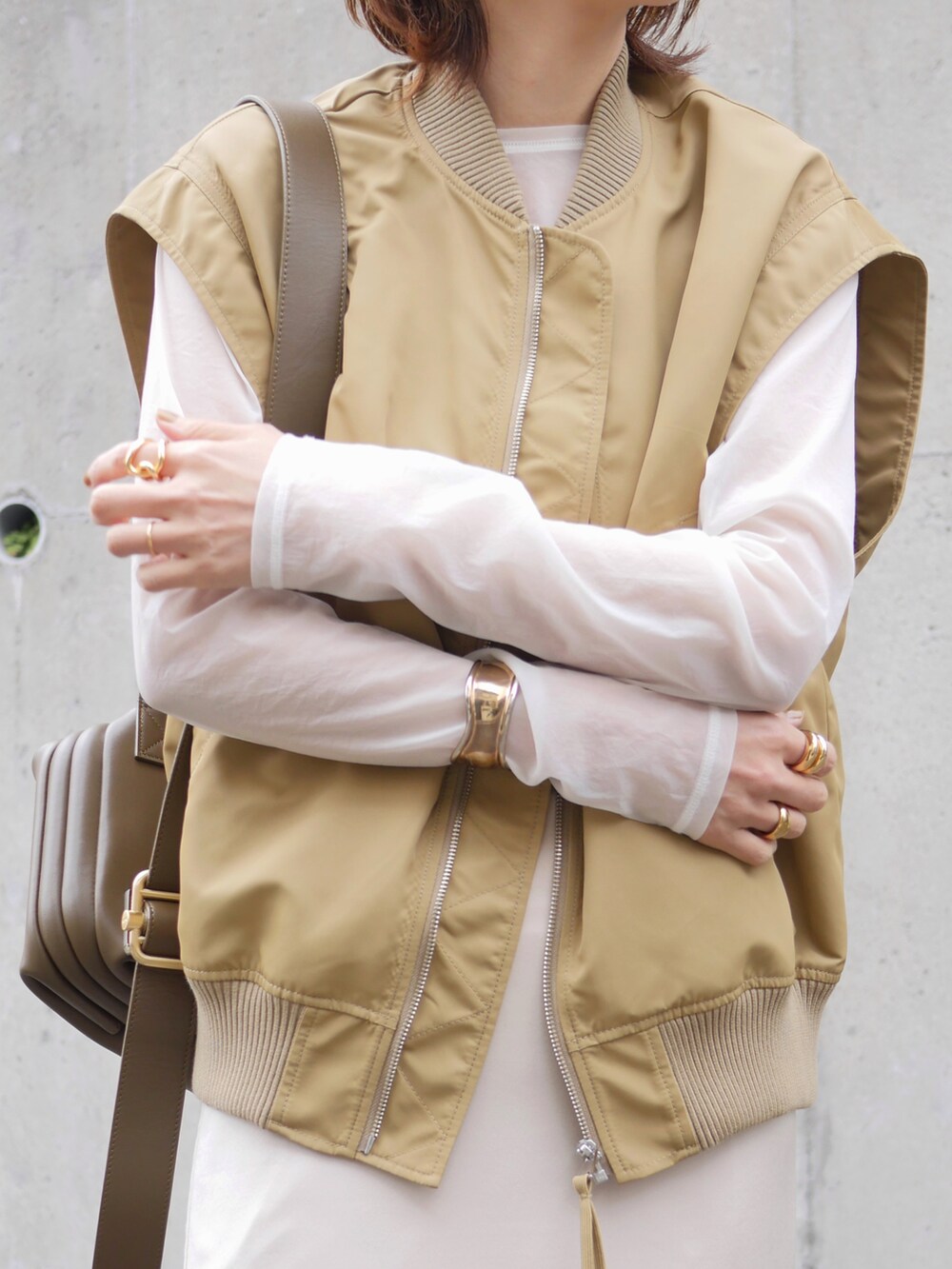 ベージュ系のその他アウター、ホワイト系のTシャツ/カットソー、グリーン系のショルダーバッグを着用したレディースの春コーディネートの5枚目の写真