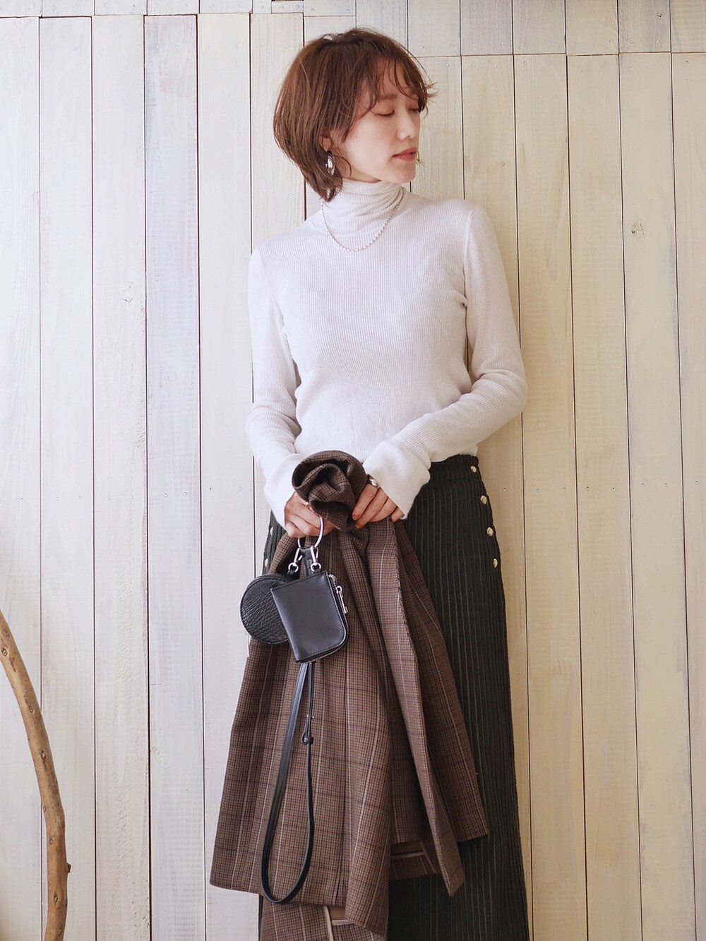 ホワイト系のニット/セーター、ブラウン系のノーカラージャケット、ブラック系のショルダーバッグを着用したレディースの秋コーディネートの4枚目の写真