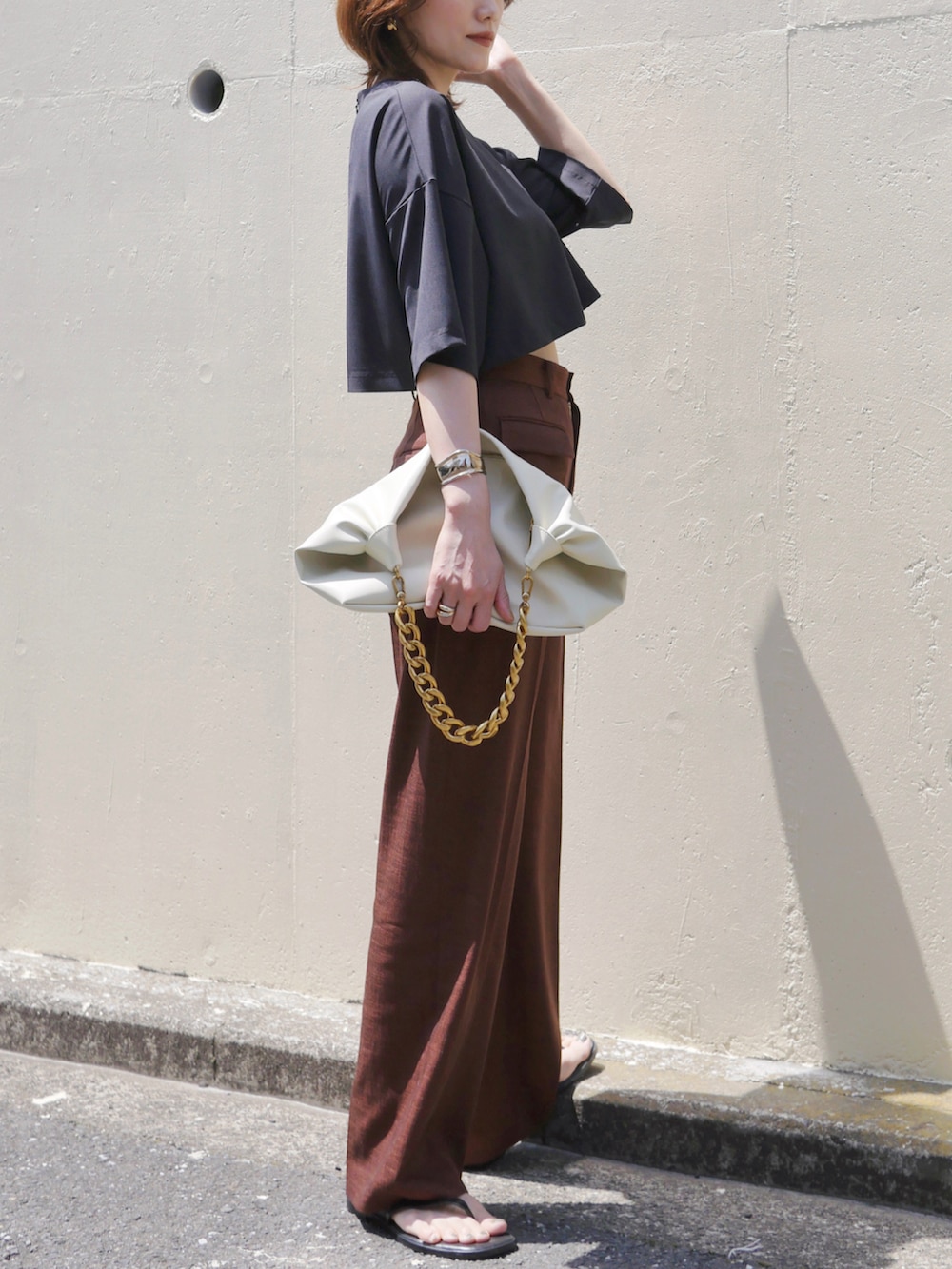 レッド系のスラックス、ホワイト系のショルダーバッグ、ブラック系のTシャツ/カットソーを着用したレディースの春コーディネートの5枚目の写真