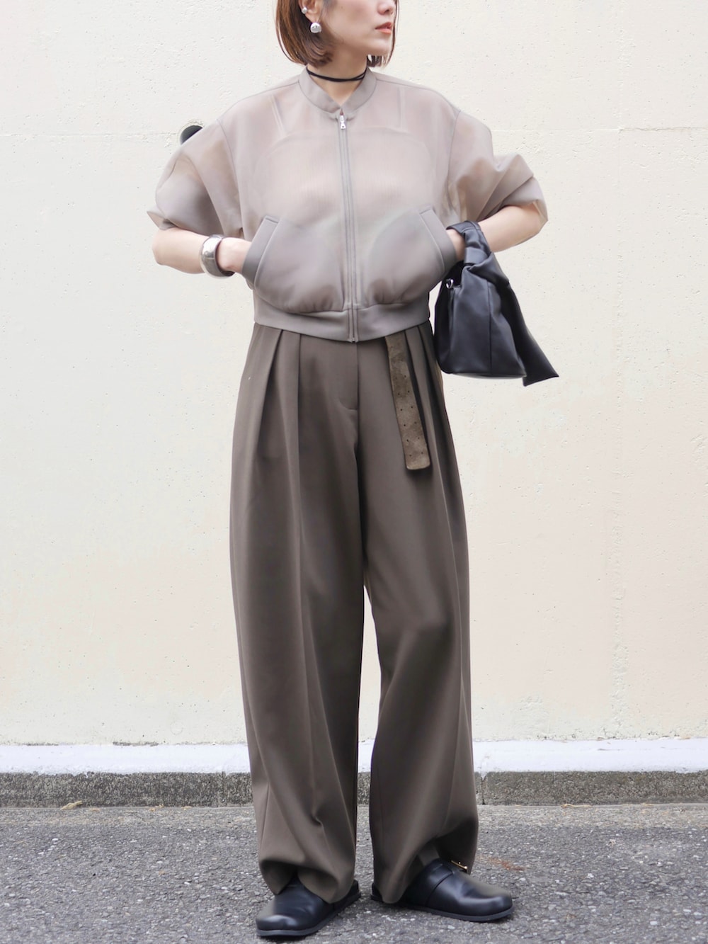 ベージュ系のブルゾン、グリーン系のその他パンツ、ブラック系のショルダーバッグを着用したレディースの春コーディネートの2枚目の写真