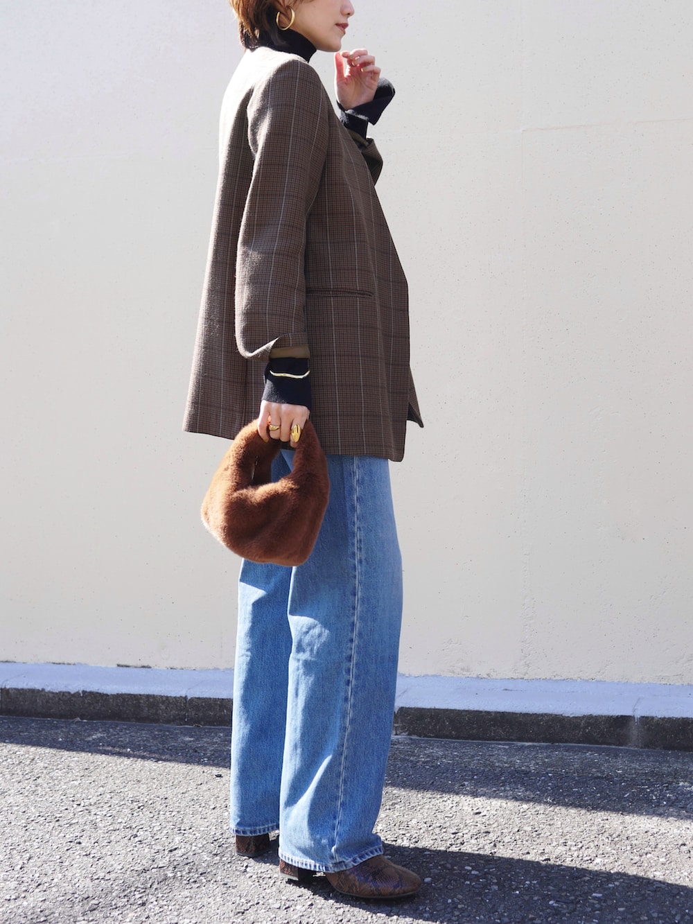 ブラック系のニット/セーター、ブラウン系のハンドバッグ、ブラウン系のノーカラージャケットを着用したレディースの冬コーディネートの4枚目の写真