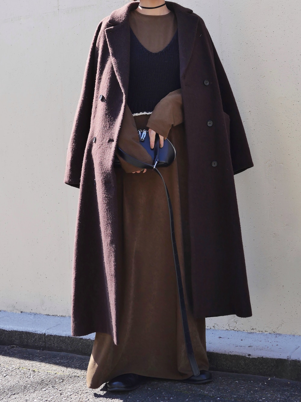 ブラウン系のワンピース、ブラウン系のその他アウター、ブラック系のニット/セーターを着用したレディースの冬コーディネートの3枚目の写真