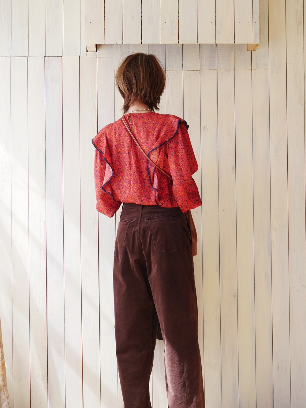 レッド系のシャツ/ブラウス、グリーン系のテーラードジャケット、ブラウン系のブーツを着用したレディースの春コーディネートの3枚目の写真