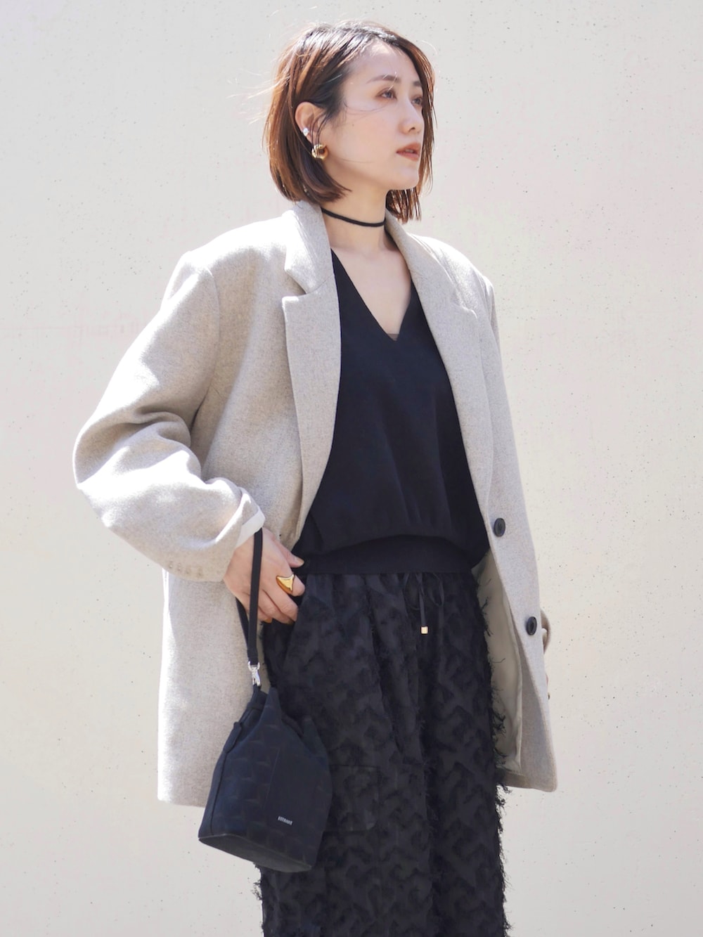 ブラック系のその他パンツ、ベージュ系のテーラードジャケット、ブラック系のニット/セーターを着用したレディースの春コーディネートの5枚目の写真