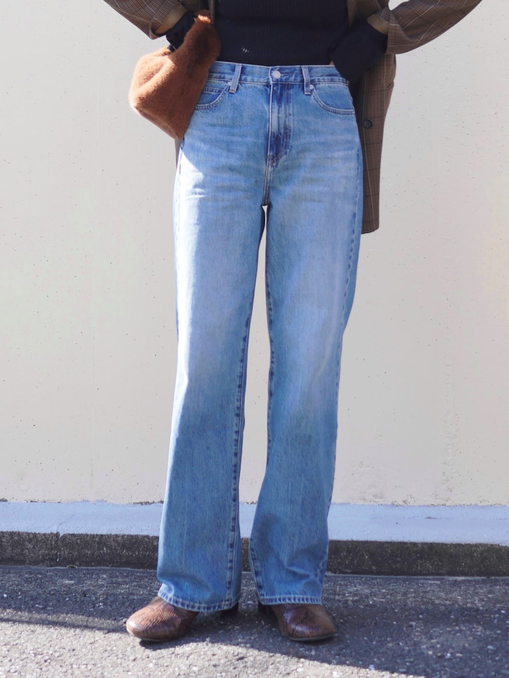 ブラック系のニット/セーター、ブラウン系のハンドバッグ、ブラウン系のノーカラージャケットを着用したレディースの冬コーディネートの5枚目の写真