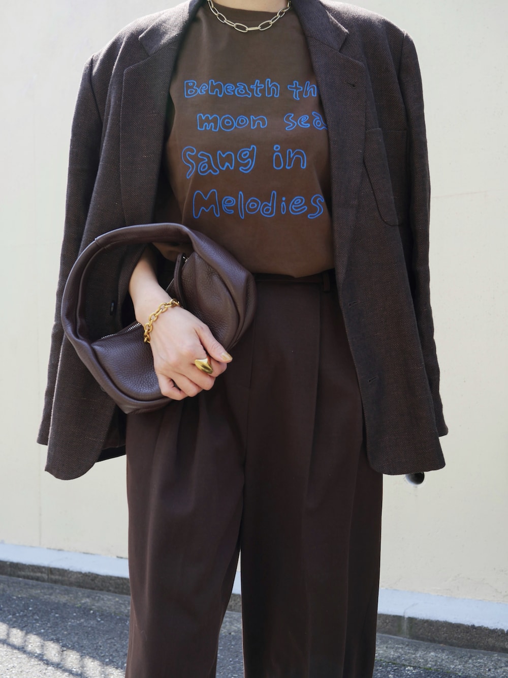 ブラウン系のTシャツ/カットソー、ブラウン系のテーラードジャケット、ブラウン系のスラックスを着用したレディースの春コーディネートの2枚目の写真