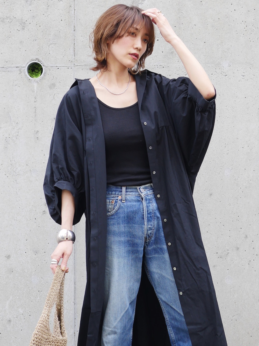 ブラック系のワンピース、ブラック系のサンダル、ベージュ系のトートバッグを着用したレディースの夏コーディネートの5枚目の写真