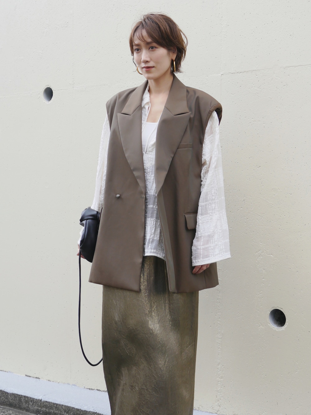 グリーン系のテーラードジャケット、ゴールド系のスカート、ホワイト系のシャツ/ブラウスを着用したレディースの秋コーディネートの3枚目の写真