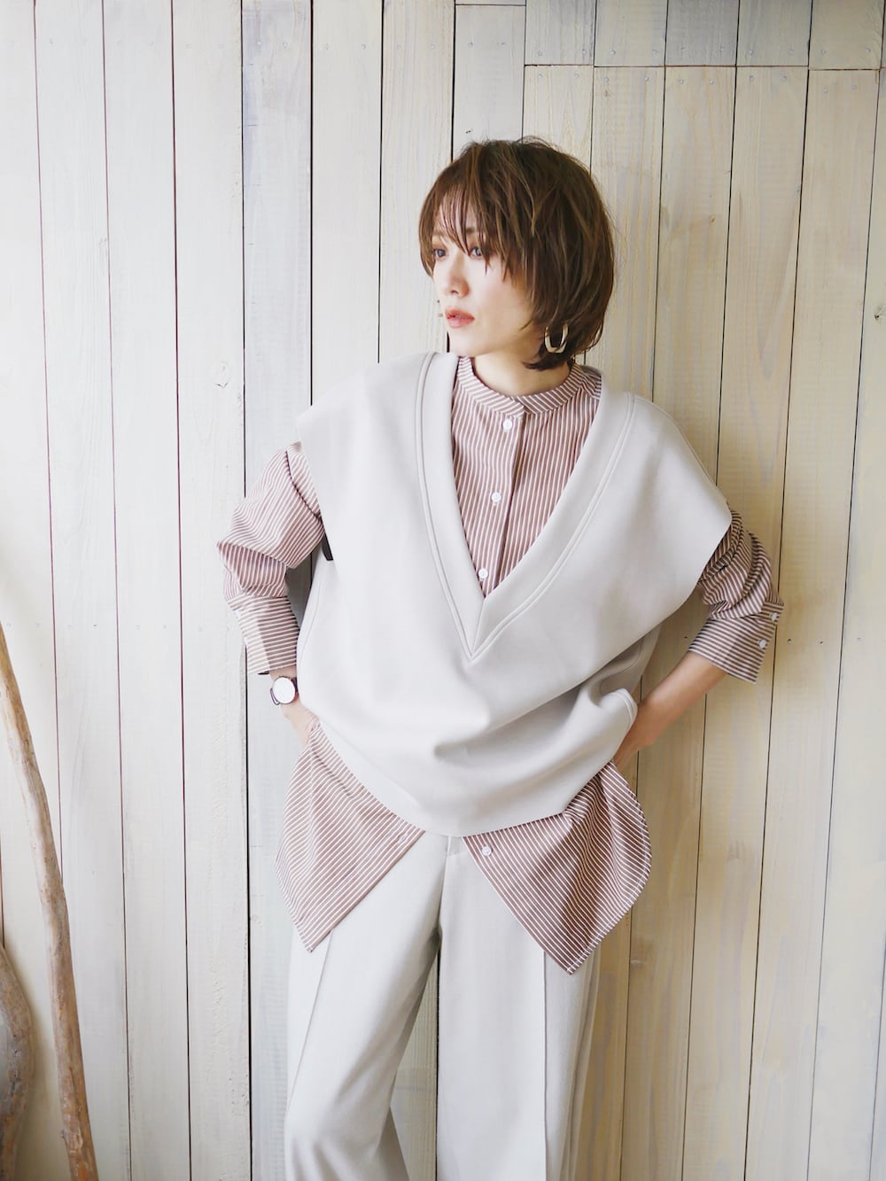 ブラウン系のシャツ/ブラウス、グレー系のベスト、ホワイト系のスラックスを着用したレディースの春コーディネートの5枚目の写真