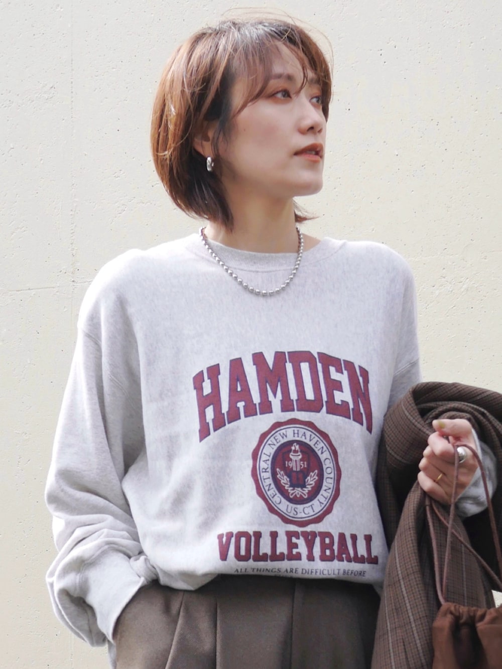 グレー系のスウェット、ブラウン系のその他パンツ、ブラウン系のトートバッグを着用したレディースの冬コーディネートの2枚目の写真