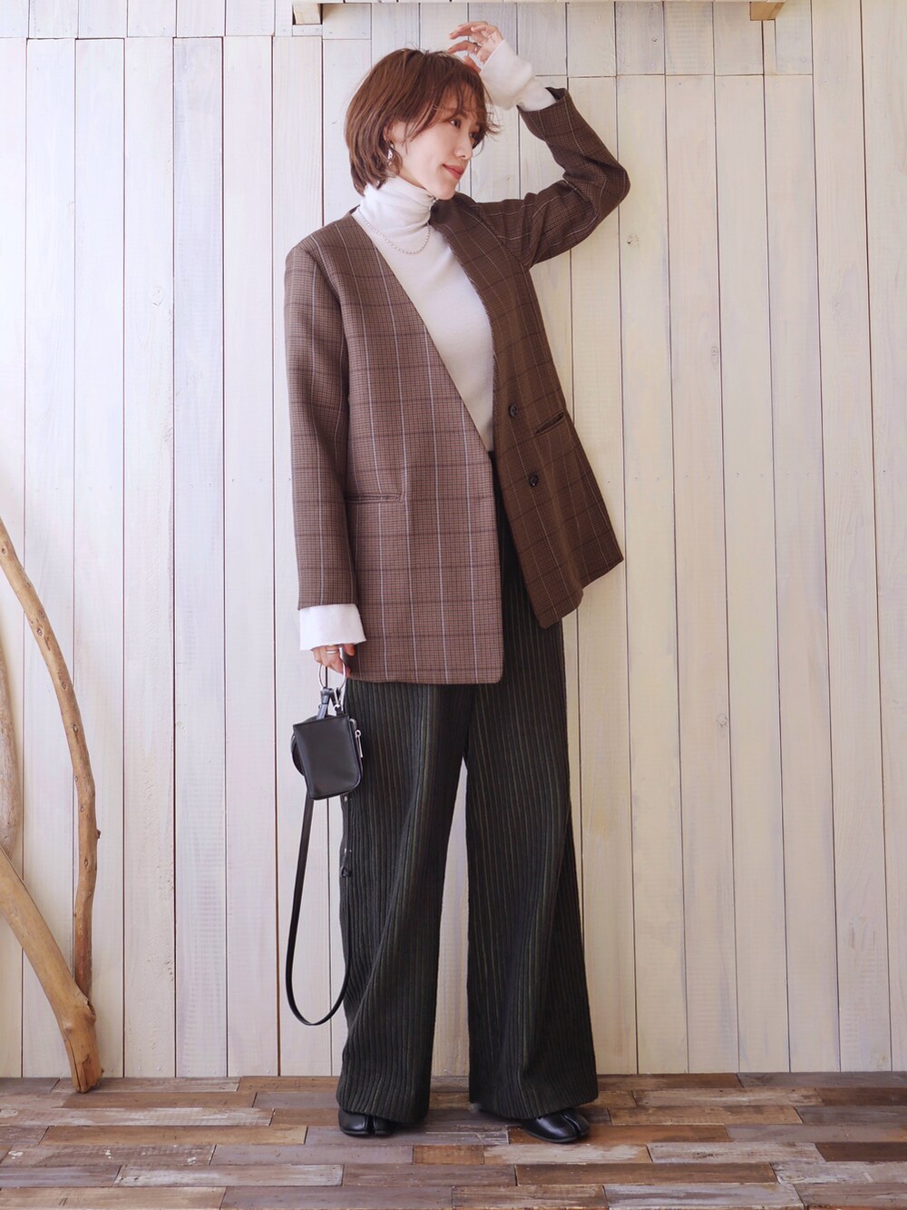 ホワイト系のニット/セーター、ブラウン系のノーカラージャケット、ブラック系のショルダーバッグを着用したレディースの秋コーディネートの2枚目の写真