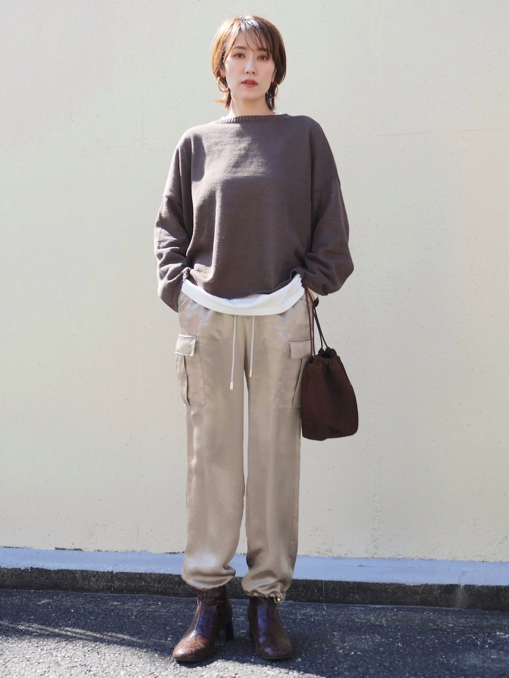 ブラウン系のニット/セーター、ベージュ系のカーゴパンツ、ブラウン系のトートバッグを着用したレディースの冬コーディネートの3枚目の写真