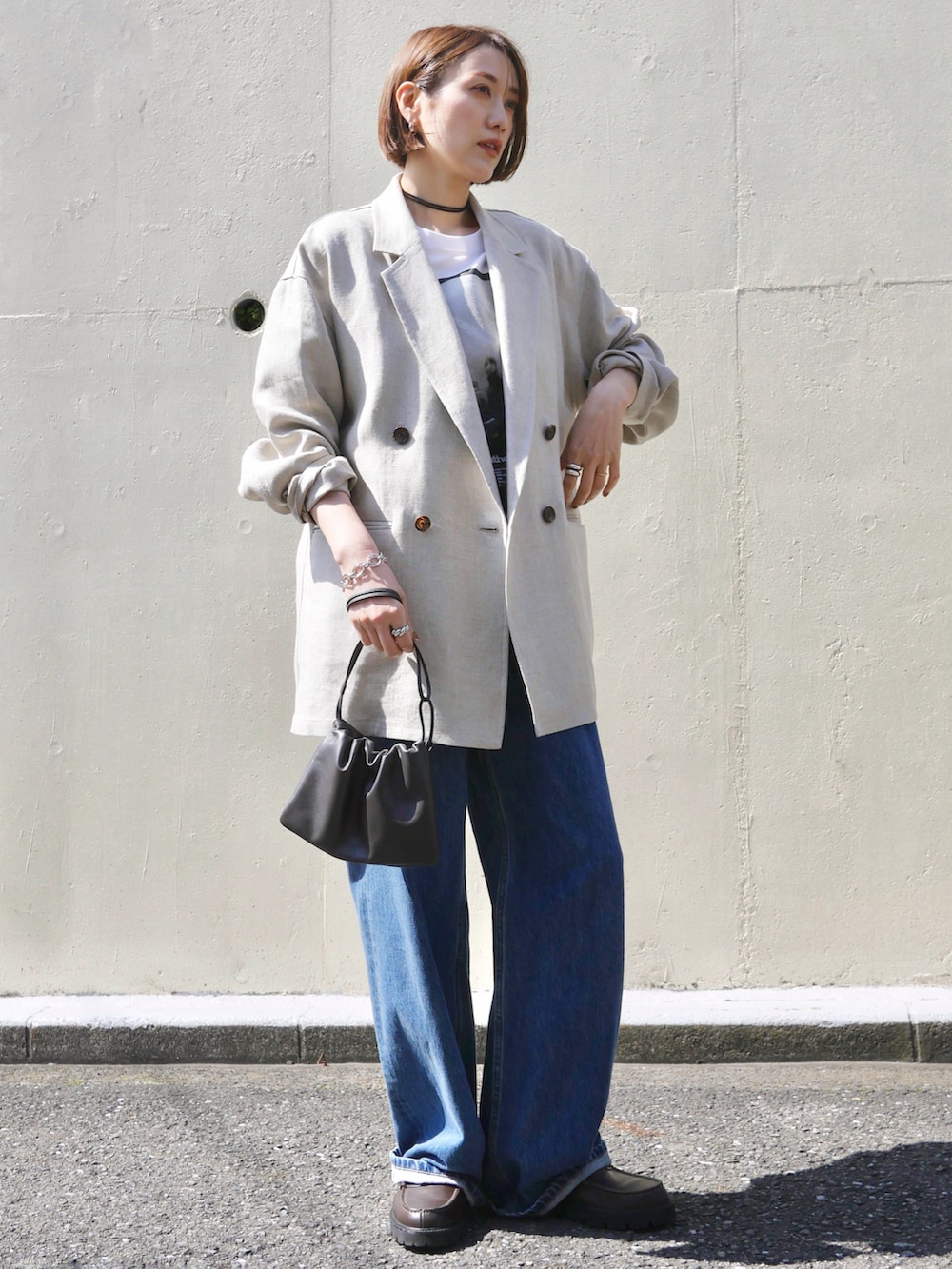 ホワイト系のTシャツ/カットソー、ブルー系のデニムパンツ、ブラウン系のショルダーバッグを着用したレディースの春コーディネートの4枚目の写真
