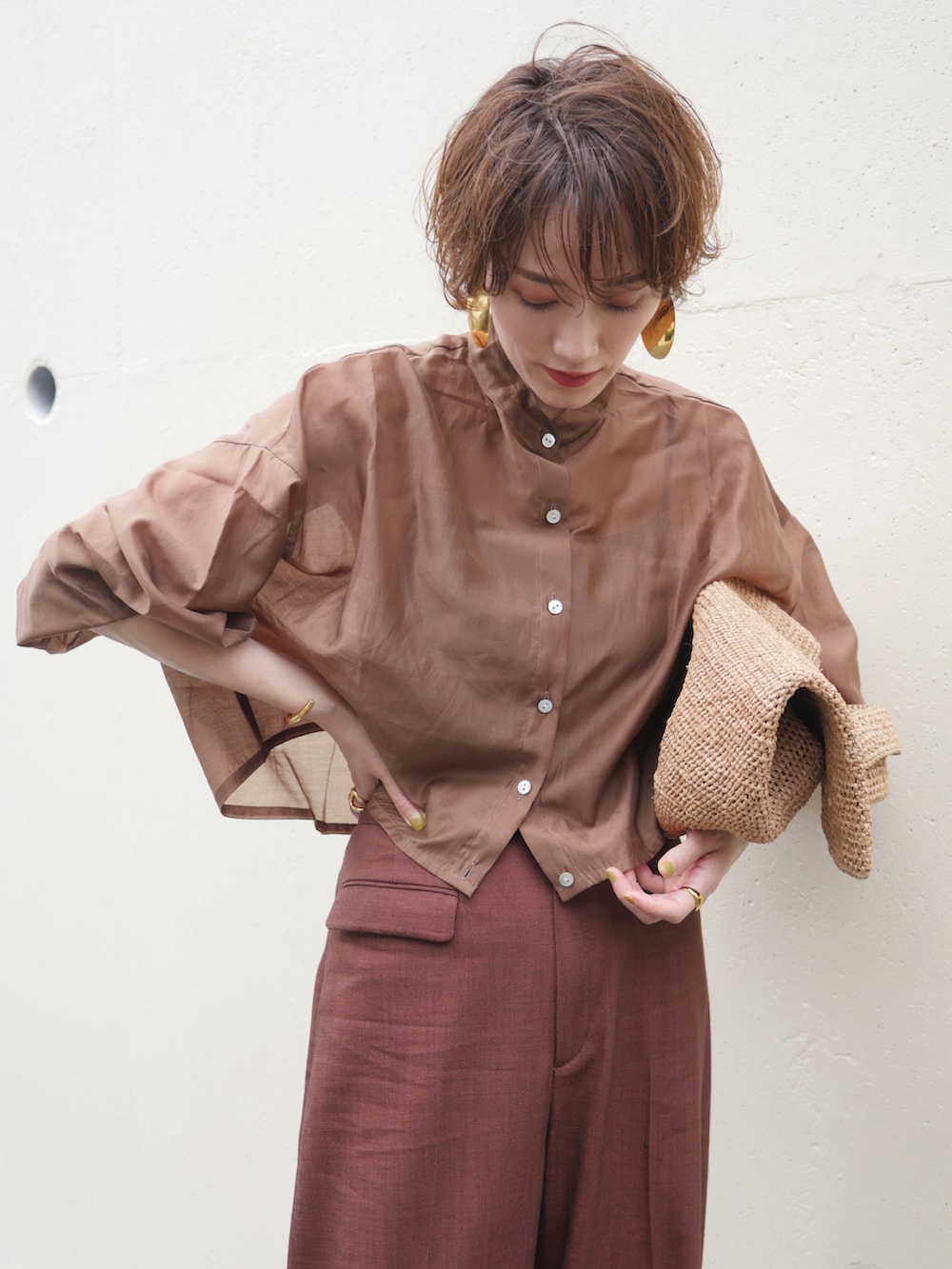 ブラウン系のシャツ/ブラウス、レッド系のスラックス、ブラウン系のかごバッグを着用したレディースの夏コーディネートの4枚目の写真