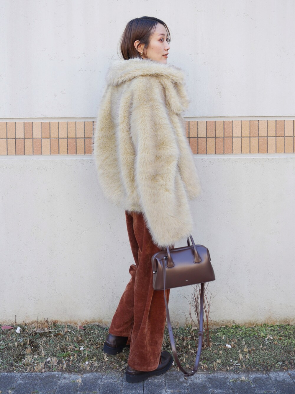 ホワイト系のその他アウター、ブラウン系のショルダーバッグ、ブラウン系のその他パンツを着用したレディースの冬コーディネートの5枚目の写真
