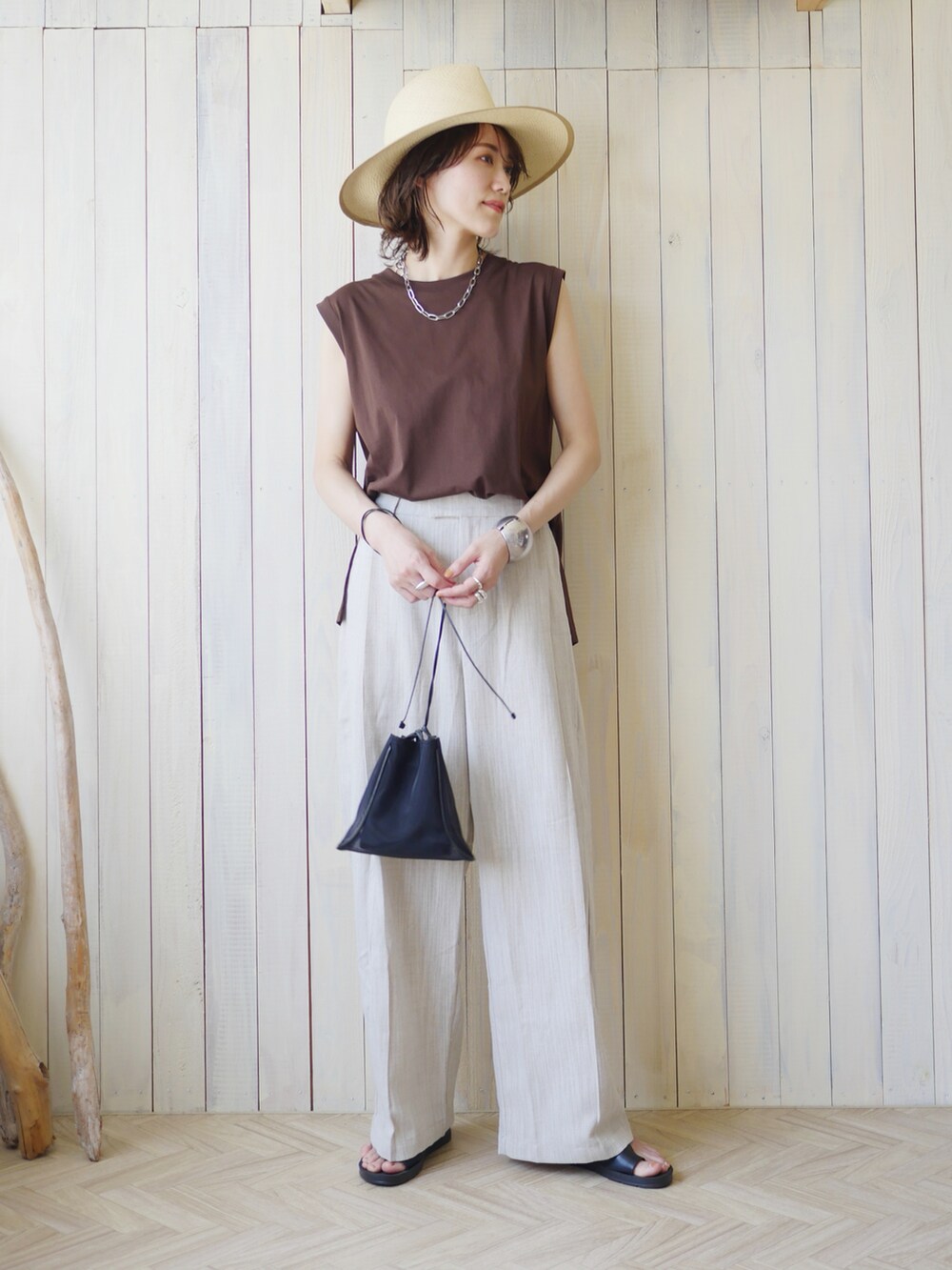ベージュ系のその他パンツ、ブラウン系のTシャツ/カットソー、ブラック系のショルダーバッグを着用したレディースの夏コーディネートの2枚目の写真