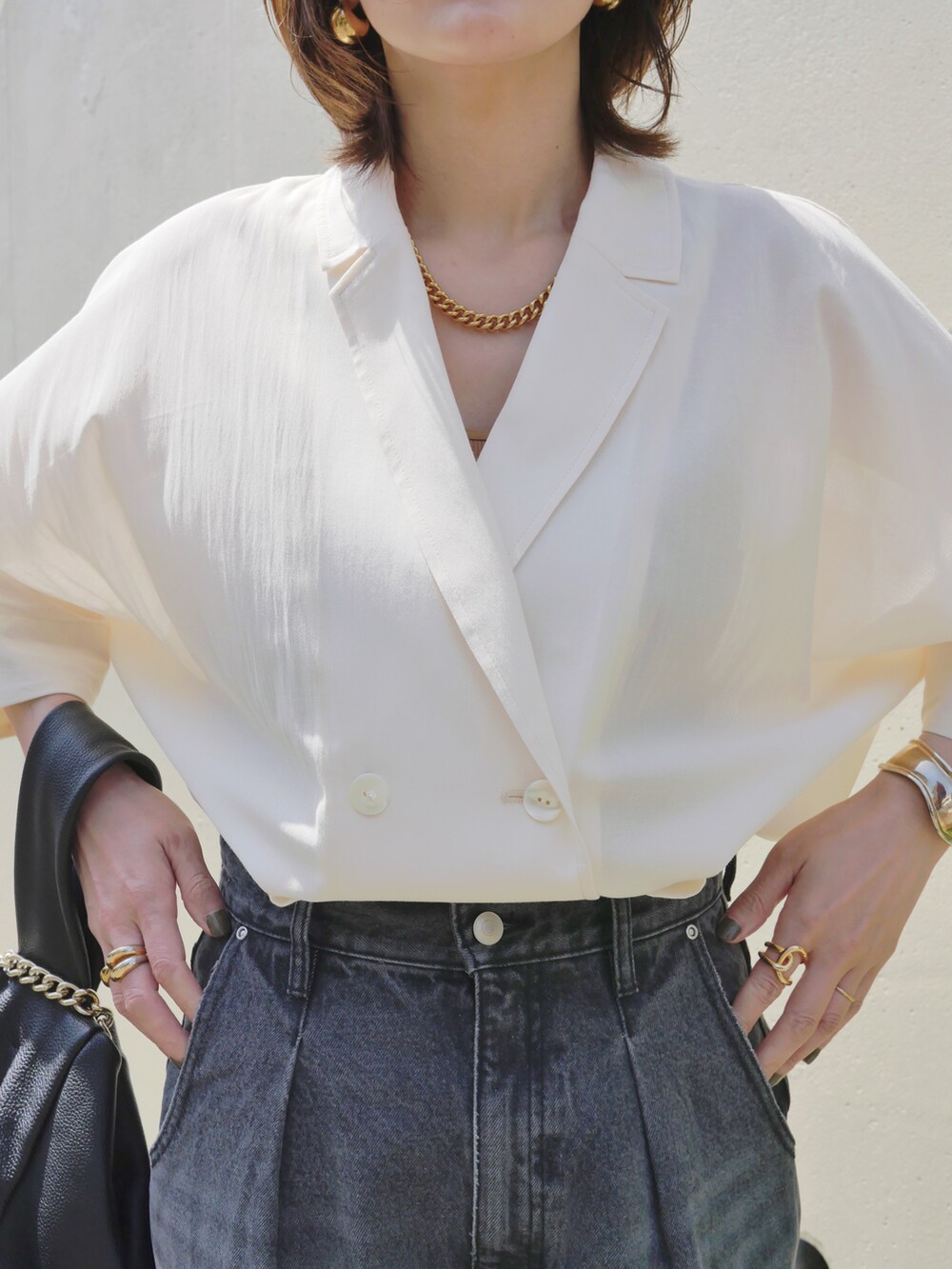 グレー系のデニムパンツ、ホワイト系のテーラードジャケット、ブラック系のサンダルを着用したレディースの春コーディネートの5枚目の写真