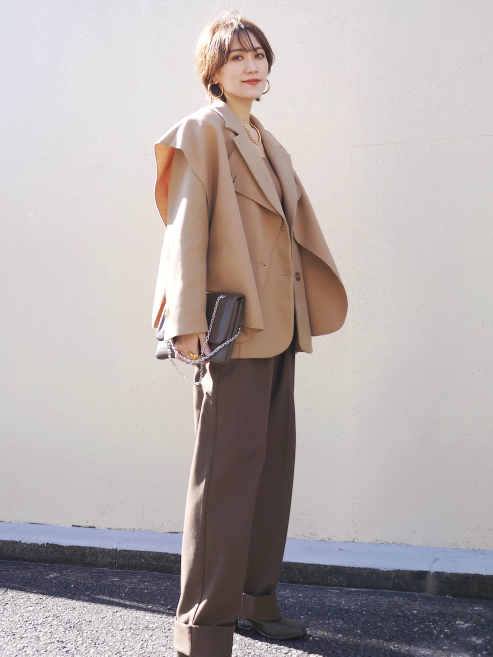 ブラウン系のその他パンツ、ブラウン系のショルダーバッグ、グリーン系のブーツを着用したレディースの冬コーディネートの4枚目の写真