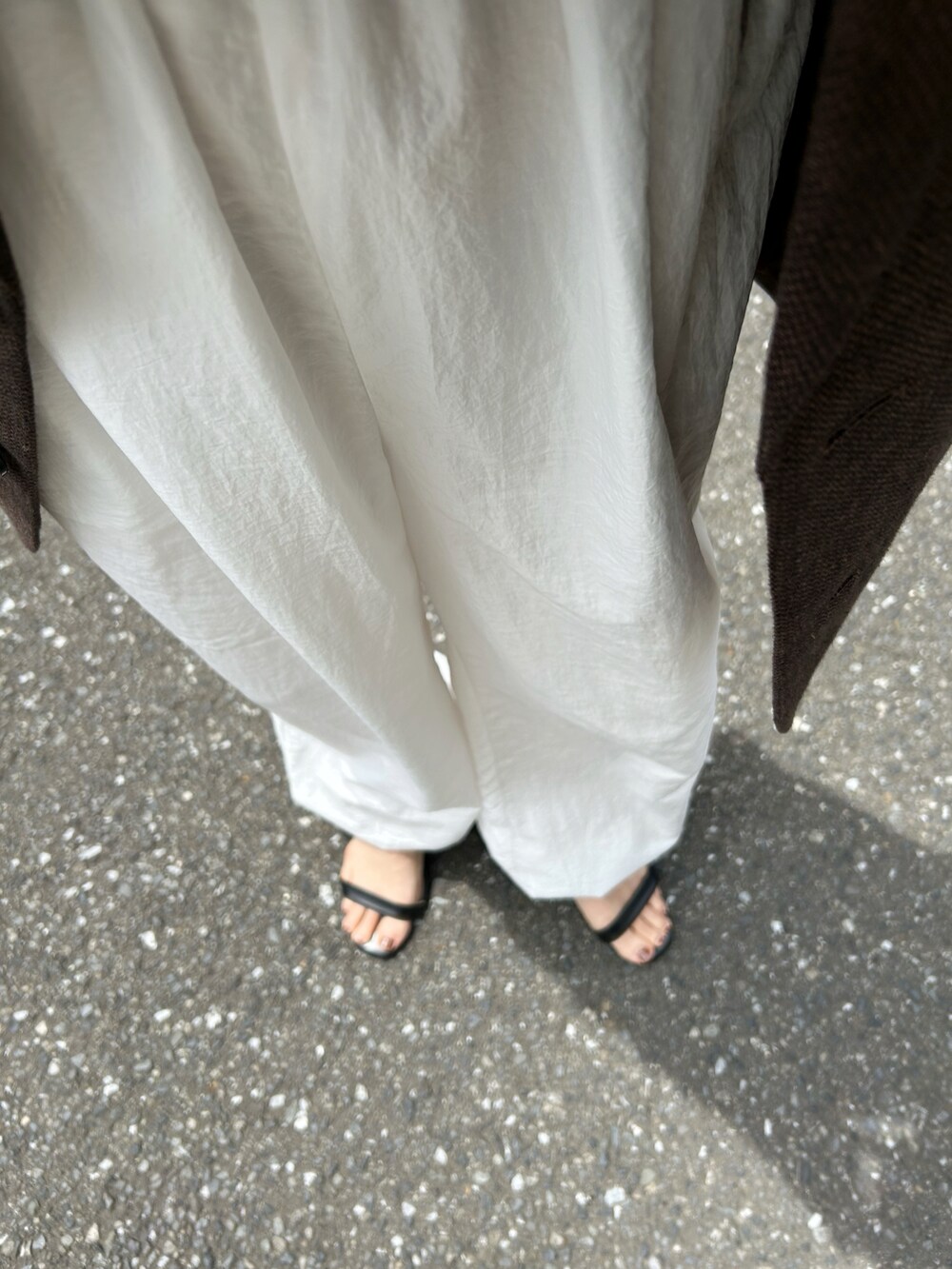 ホワイト系のその他パンツ、ブラウン系のテーラードジャケット、ブラック系のサンダルを着用したレディースの春コーディネートの3枚目の写真