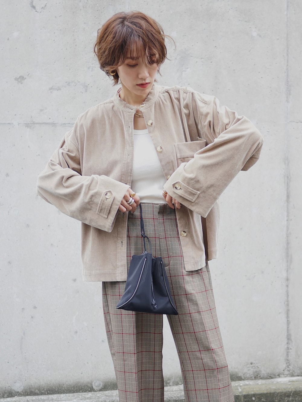 ブラウン系のブルゾン、ブラウン系のパンツ、ホワイト系のタンクトップを着用したレディースの秋コーディネートの2枚目の写真