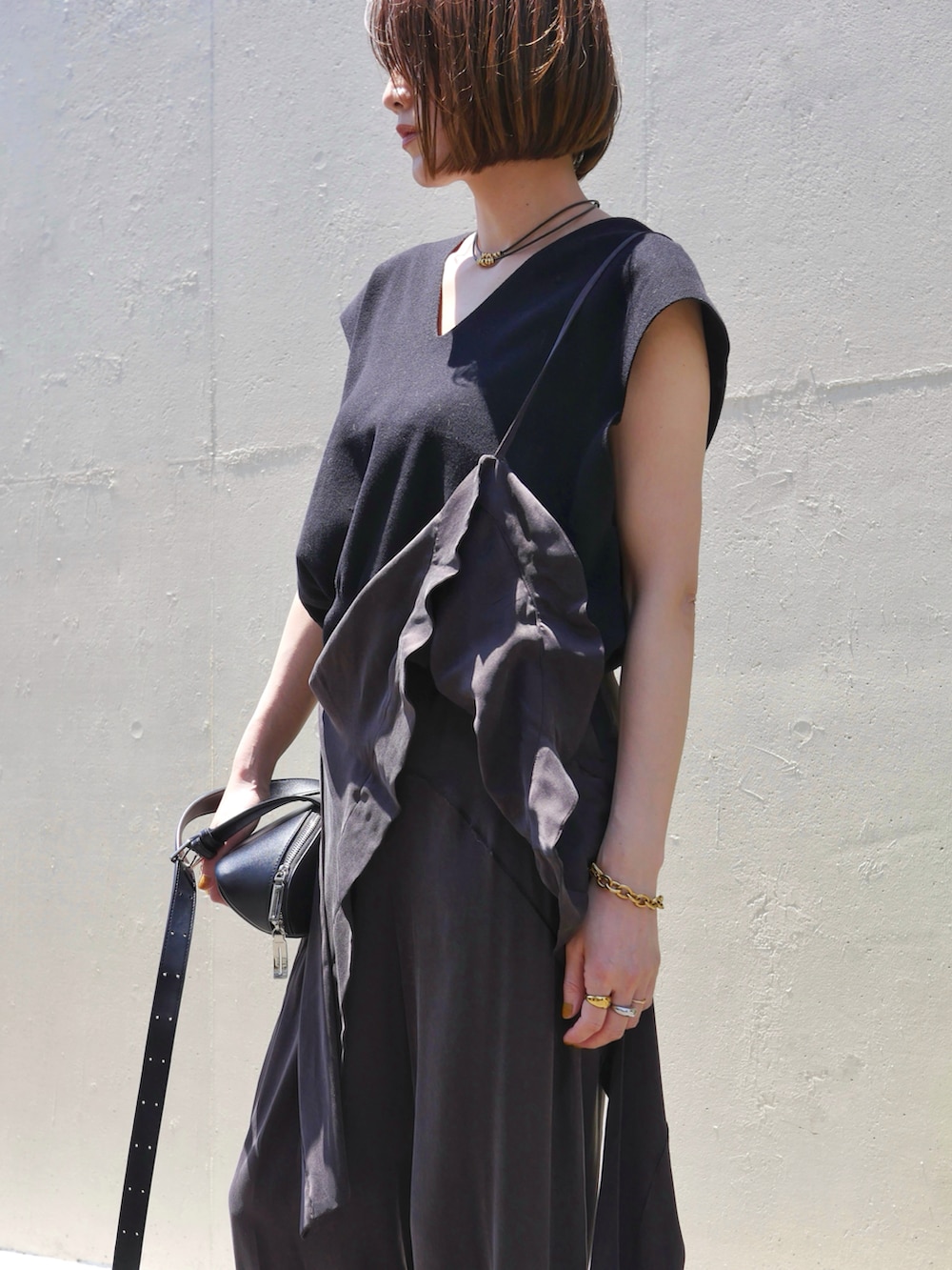 ブラウン系のその他パンツ、ブラック系のニット/セーター、ブラック系のショルダーバッグを着用したレディースの夏コーディネートの3枚目の写真