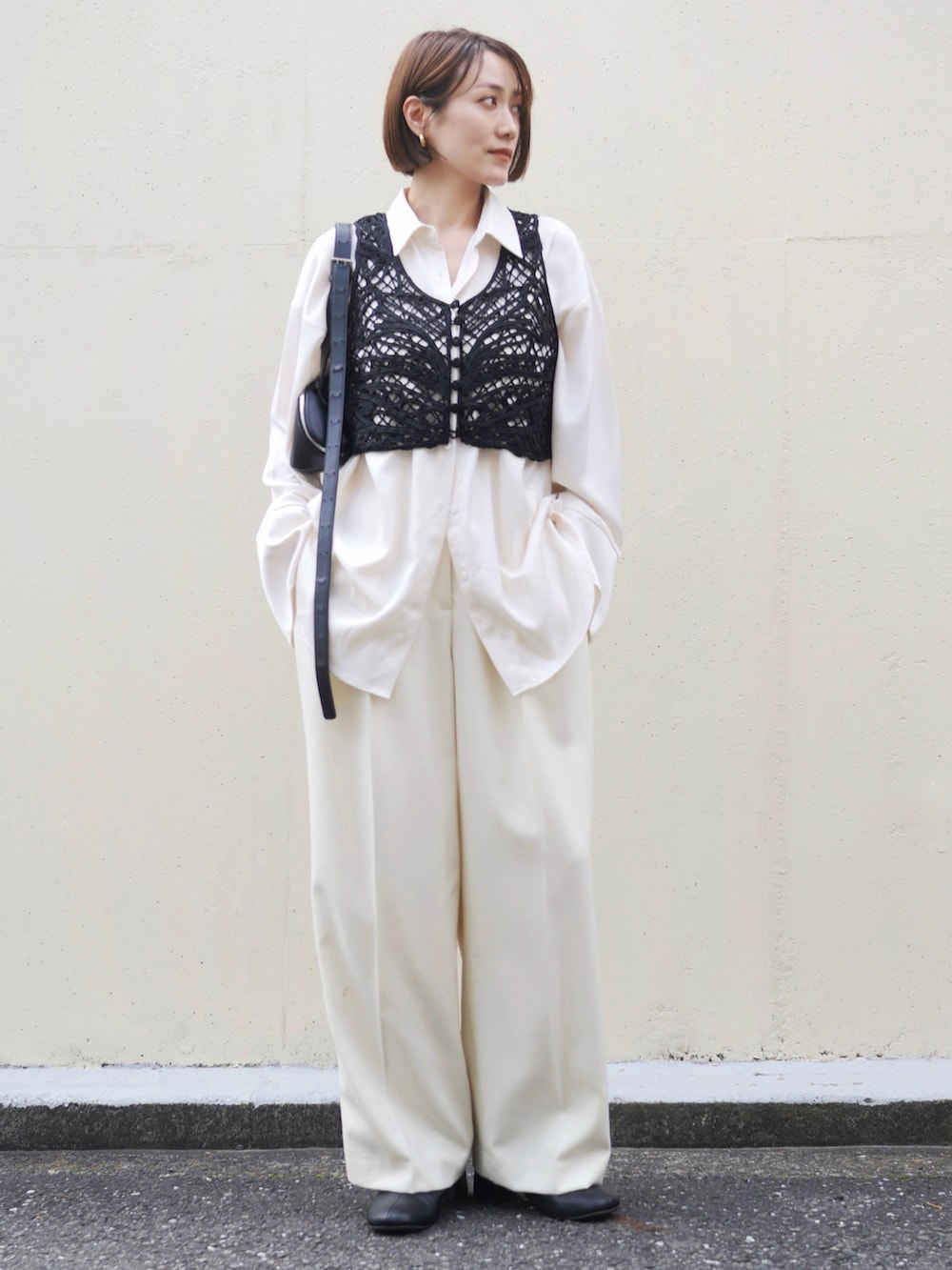 ホワイト系のシャツ/ブラウス、ブラック系のベスト、ホワイト系のスラックスを着用したレディースの春コーディネートの4枚目の写真