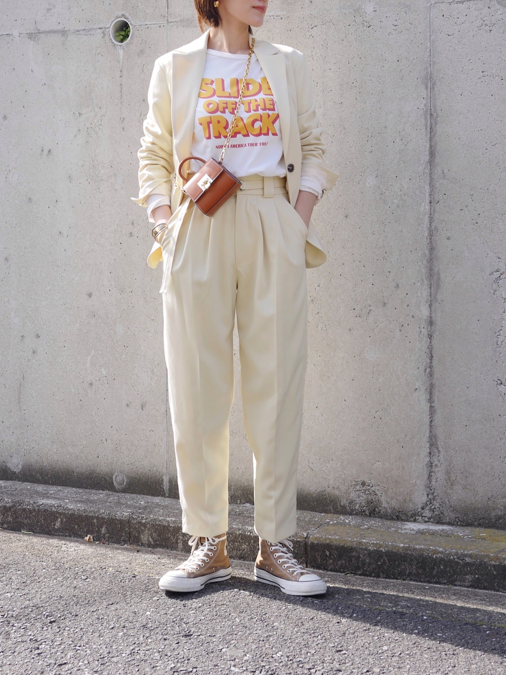 イエロー系のテーラードジャケット、イエロー系のその他パンツ、ホワイト系のTシャツ/カットソーを着用したレディースの冬コーディネートの2枚目の写真