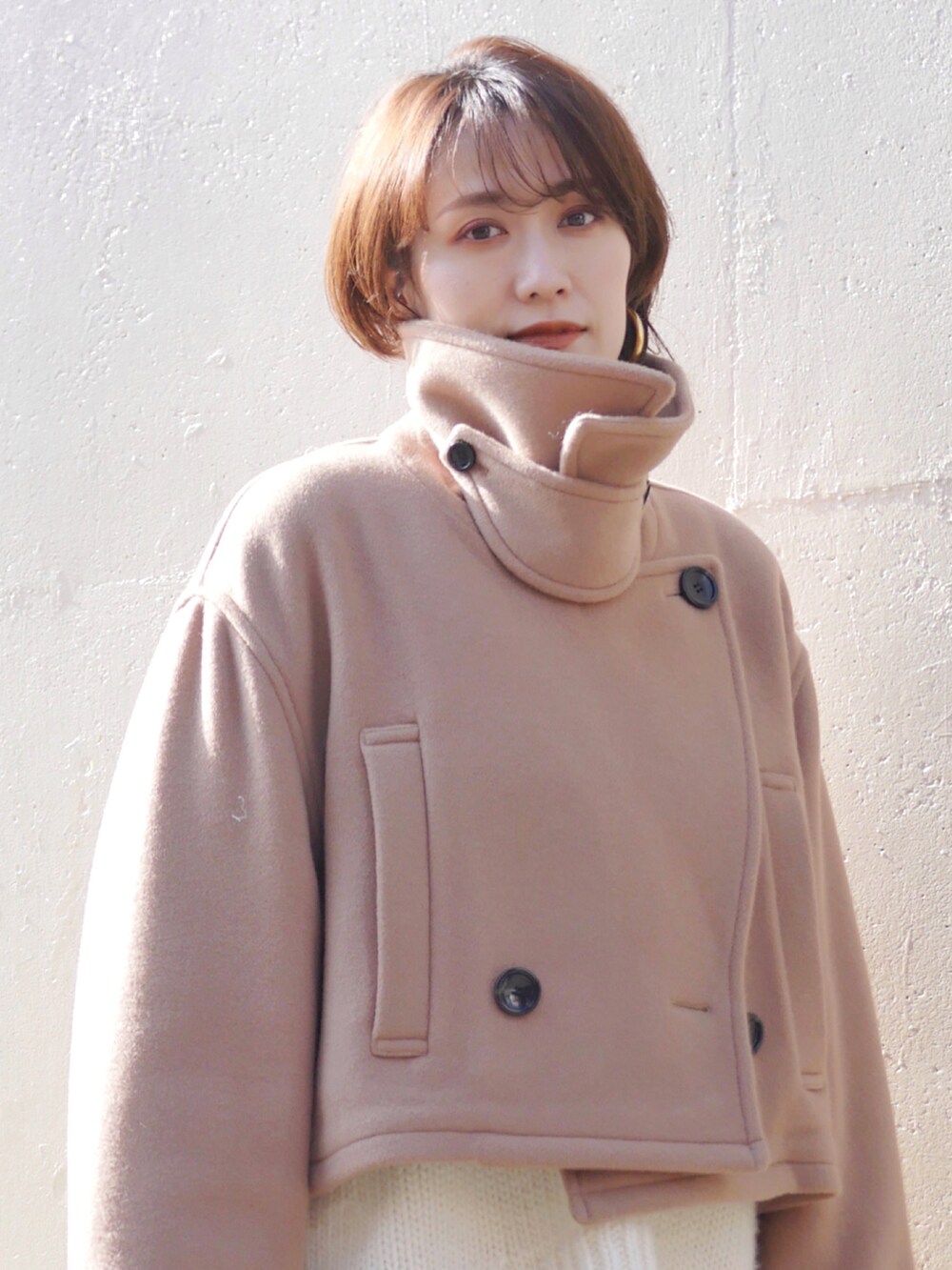 ベージュ系のピーコート、ホワイト系のニット/セーター、グリーン系のその他パンツを着用したレディースの冬コーディネートの2枚目の写真