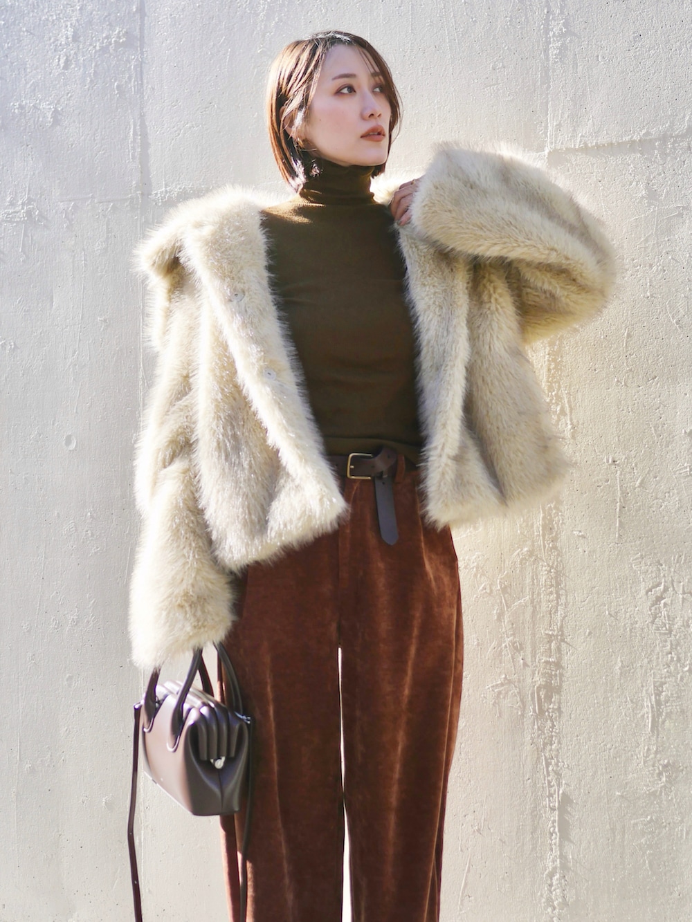 ホワイト系のその他アウター、ブラウン系のショルダーバッグ、ブラウン系のその他パンツを着用したレディースの冬コーディネートの4枚目の写真