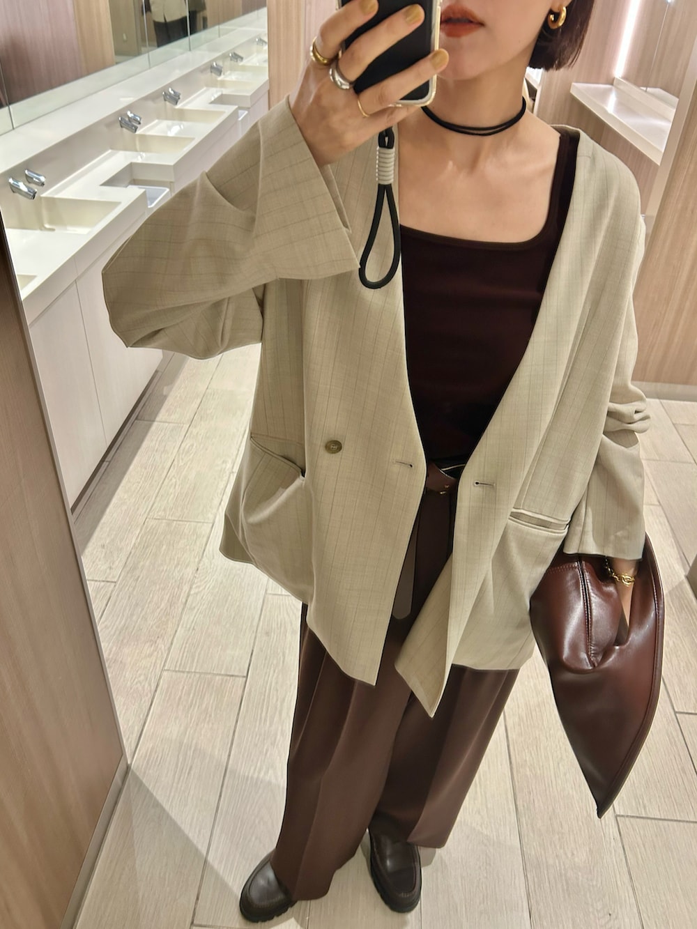 ブラウン系のタンクトップ、ベージュ系のノーカラージャケット、ブラウン系のローファーを着用したレディースの秋コーディネートの3枚目の写真