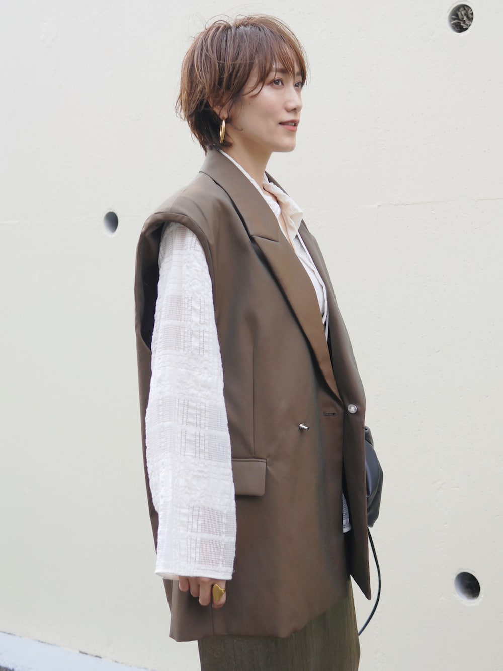 グリーン系のテーラードジャケット、ゴールド系のスカート、ホワイト系のシャツ/ブラウスを着用したレディースの秋コーディネートの4枚目の写真