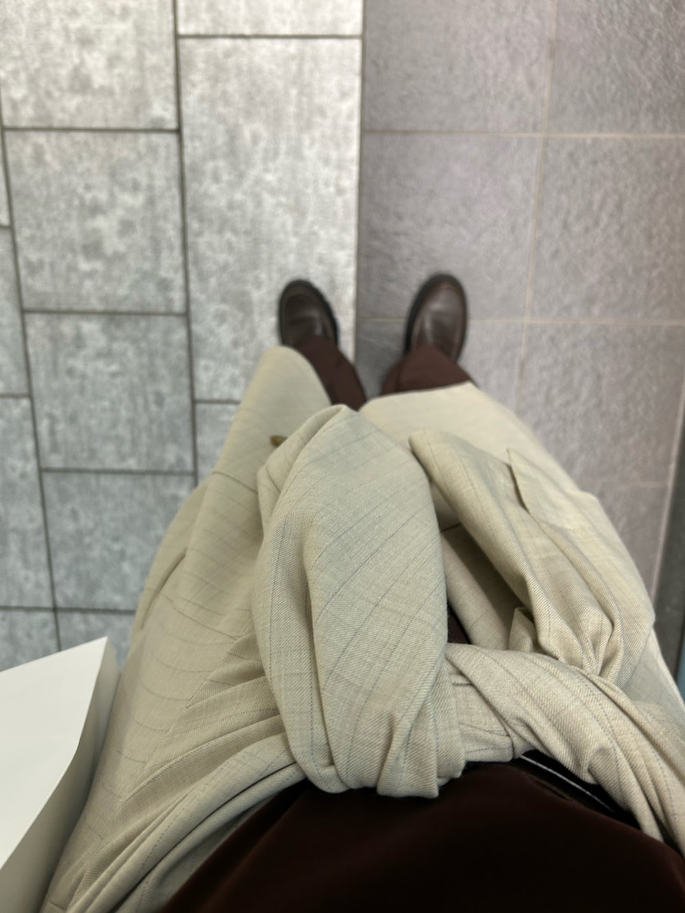 ブラウン系のタンクトップ、ベージュ系のノーカラージャケット、ブラウン系のローファーを着用したレディースの秋コーディネートの4枚目の写真