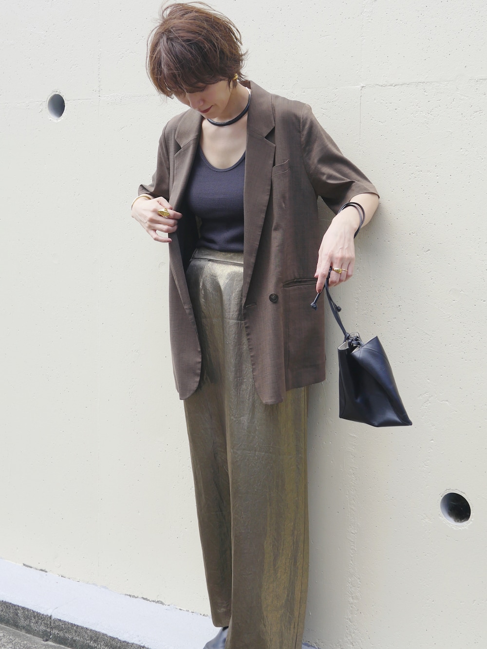 ゴールド系のスカート、ブラウン系のテーラードジャケット、ブラック系のタンクトップを着用したレディースの秋コーディネートの5枚目の写真