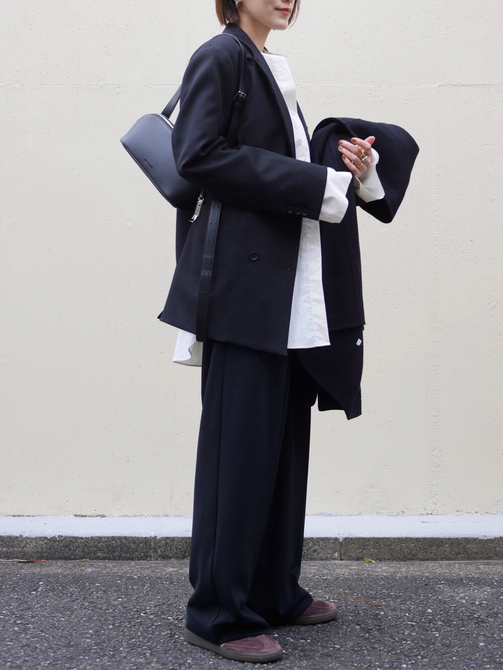 ブラック系のテーラードジャケット、ブラック系のその他パンツ、ブラック系のショルダーバッグを着用したレディースの冬コーディネートの5枚目の写真