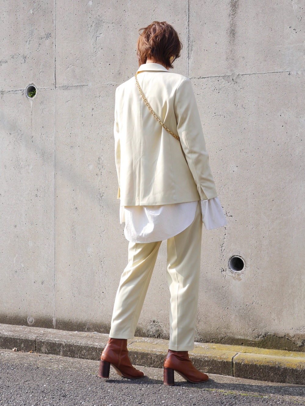 イエロー系のテーラードジャケット、イエロー系のその他パンツ、ホワイト系のシャツ/ブラウスを着用したレディースの冬コーディネートの2枚目の写真