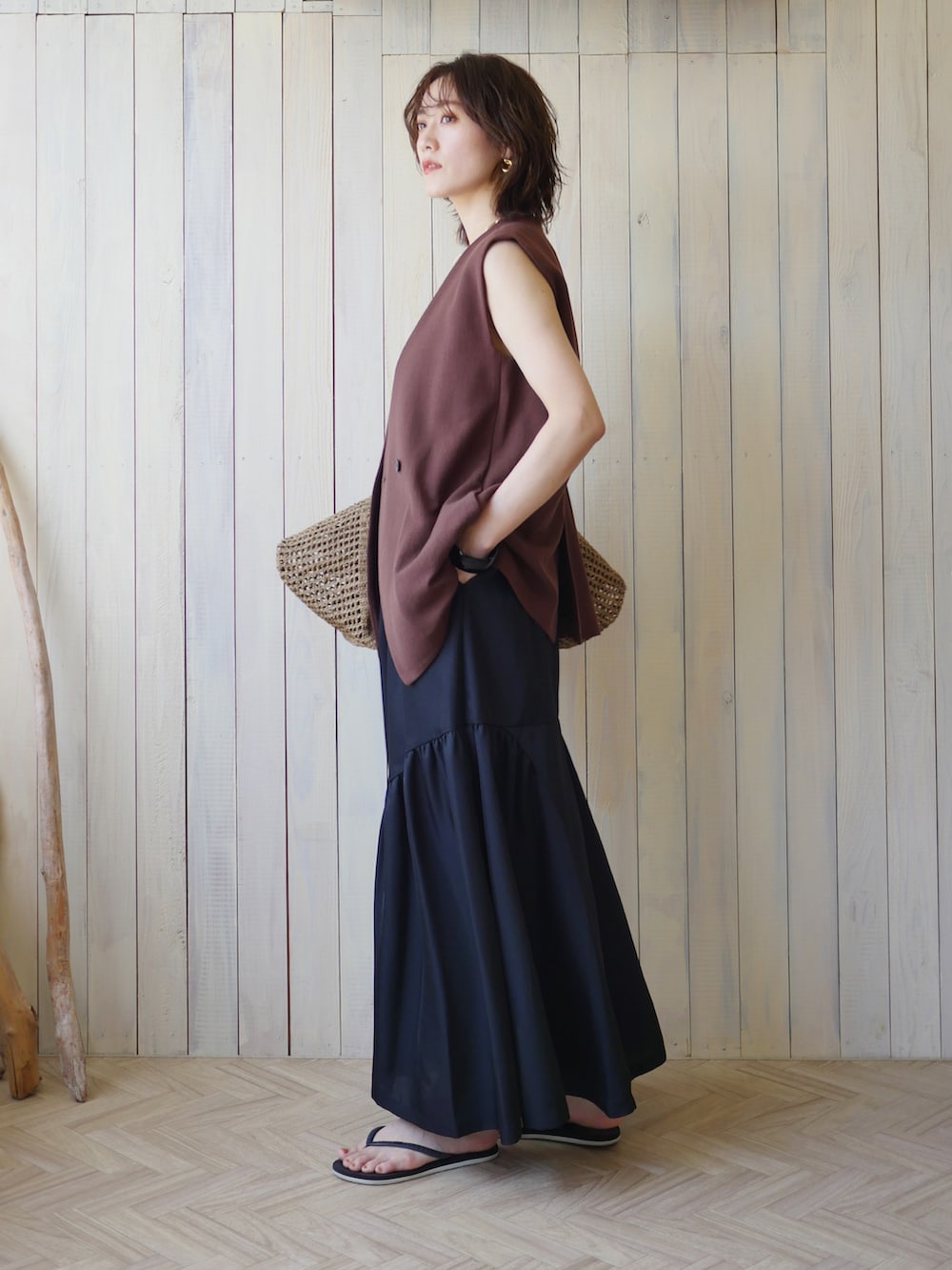 ブラック系のワンピース、ブラウン系のその他アウター、ベージュ系のかごバッグを着用したレディースの夏コーディネートの3枚目の写真