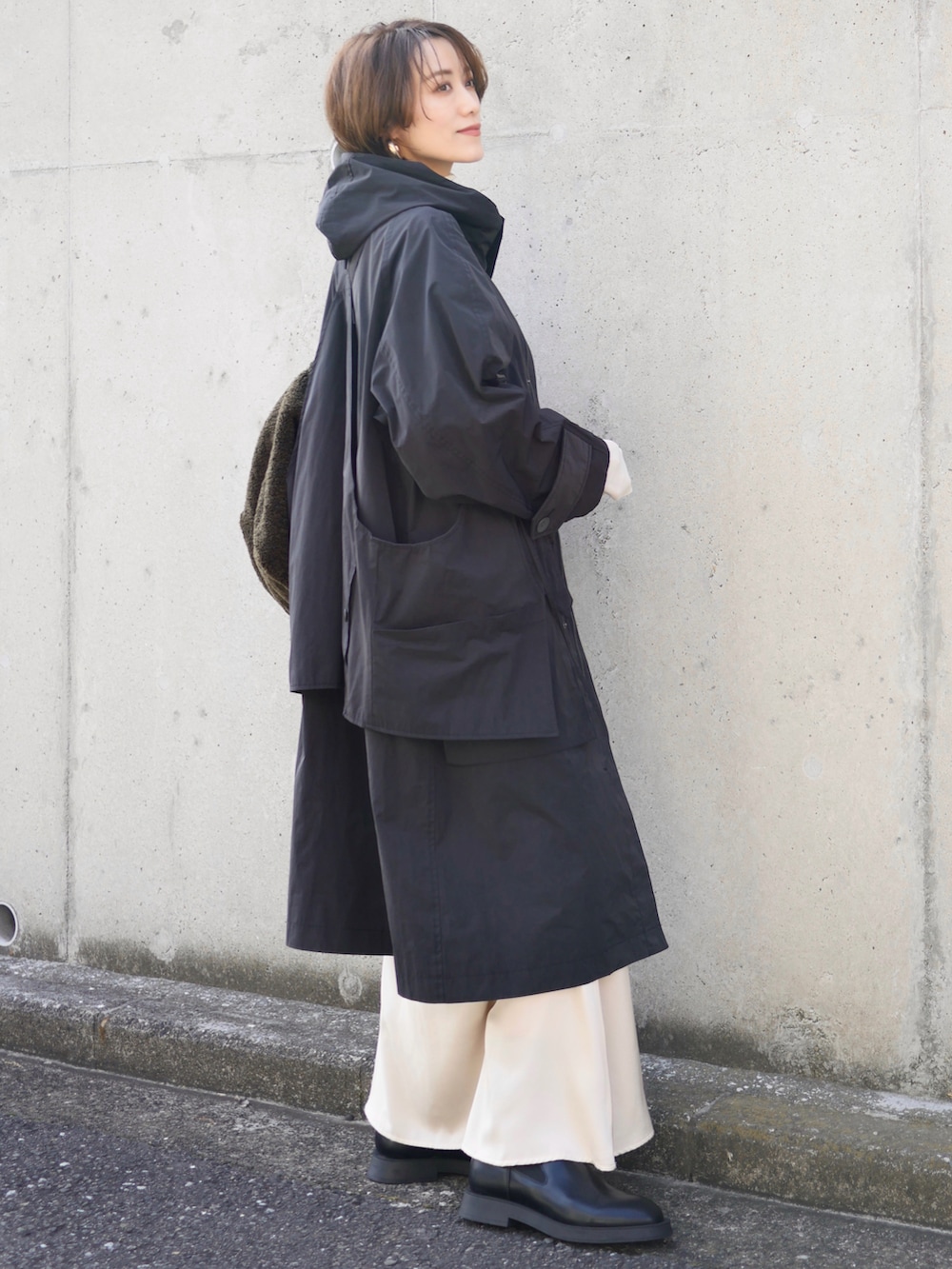 ブラック系のその他アウター、ホワイト系のスカート、ブラック系のブーツを着用したレディースの秋コーディネートの4枚目の写真