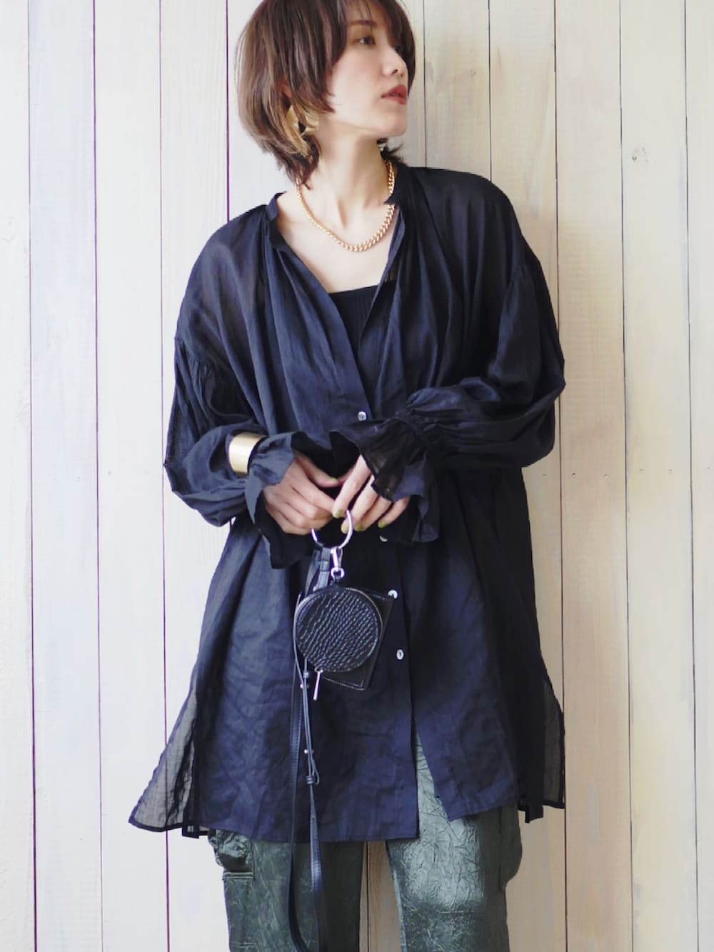 ブラック系のシャツ/ブラウス、グリーン系のカーゴパンツ、ブラック系のサンダルを着用したレディースの春コーディネートの2枚目の写真