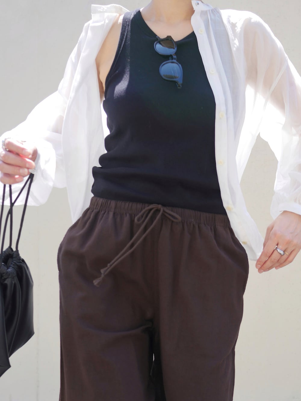 ホワイト系のシャツ/ブラウス、ブラック系のショルダーバッグ、ブラック系のサンダルを着用したレディースの夏コーディネートの3枚目の写真