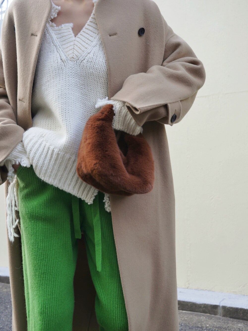 ホワイト系のニット/セーター、グリーン系のスラックス、ベージュ系のその他アウターを着用したレディースの冬コーディネートの5枚目の写真