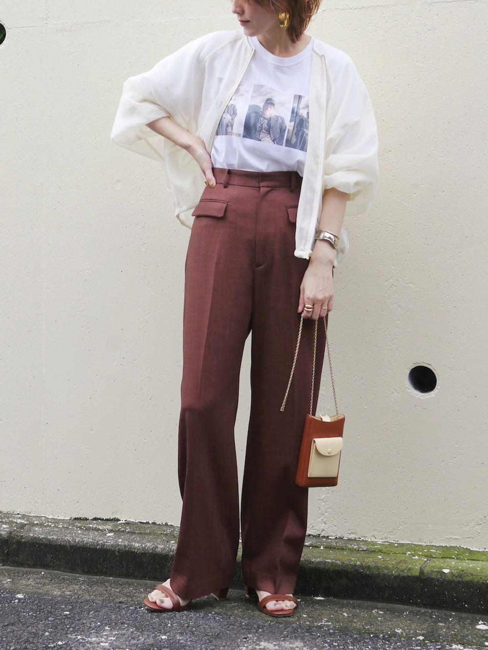 レッド系のスラックス、ホワイト系のTシャツ/カットソー、ブラウン系のサンダルを着用したレディースの春コーディネートの2枚目の写真