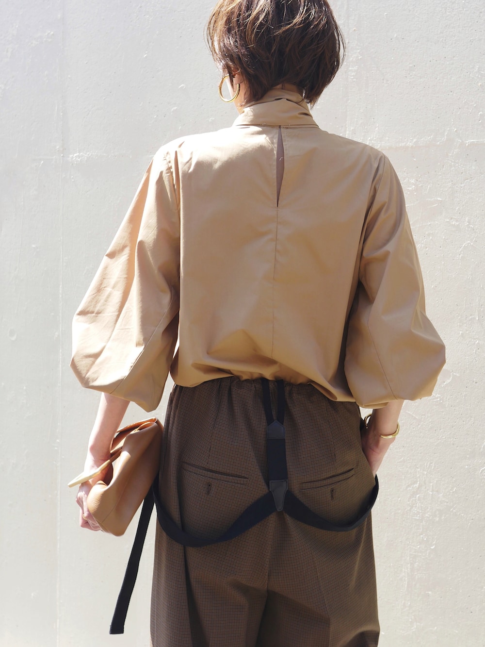 ブラウン系のシャツ/ブラウス、ブラウン系のその他パンツ、イエロー系のハンドバッグを着用したレディースの秋コーディネートの4枚目の写真
