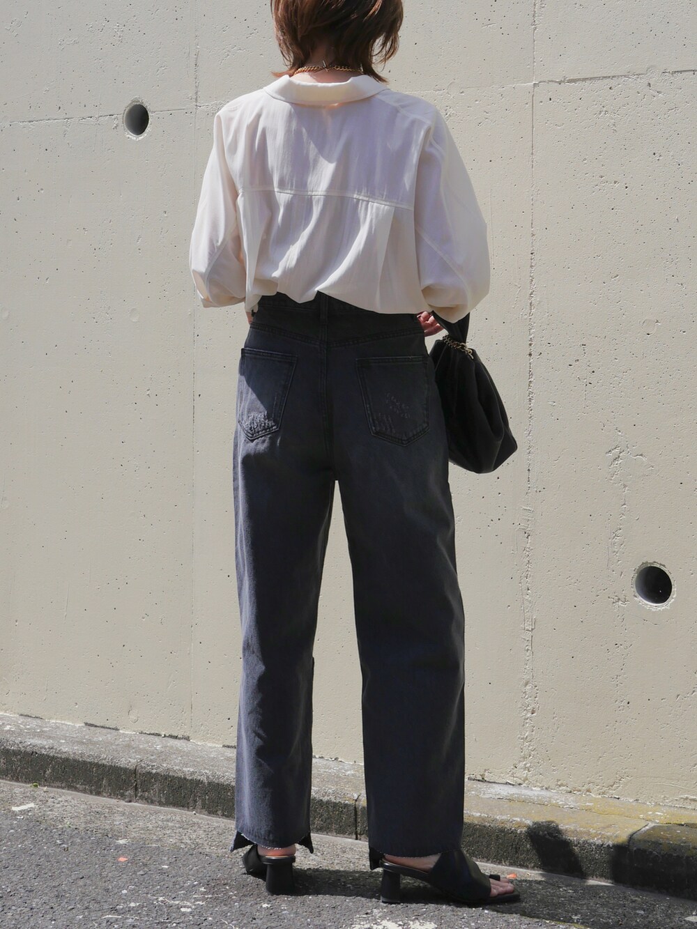 グレー系のデニムパンツ、ホワイト系のテーラードジャケット、ブラック系のサンダルを着用したレディースの春コーディネートの4枚目の写真