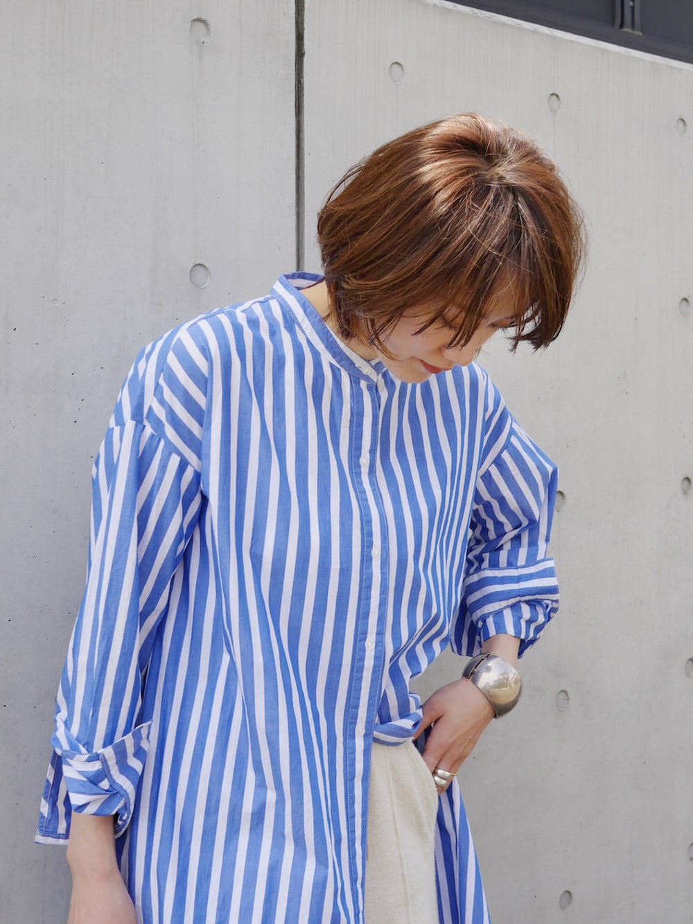 ブルー系のシャツワンピース、ベージュ系のその他パンツ、ホワイト系のスニーカーを着用したレディースの春コーディネートの3枚目の写真